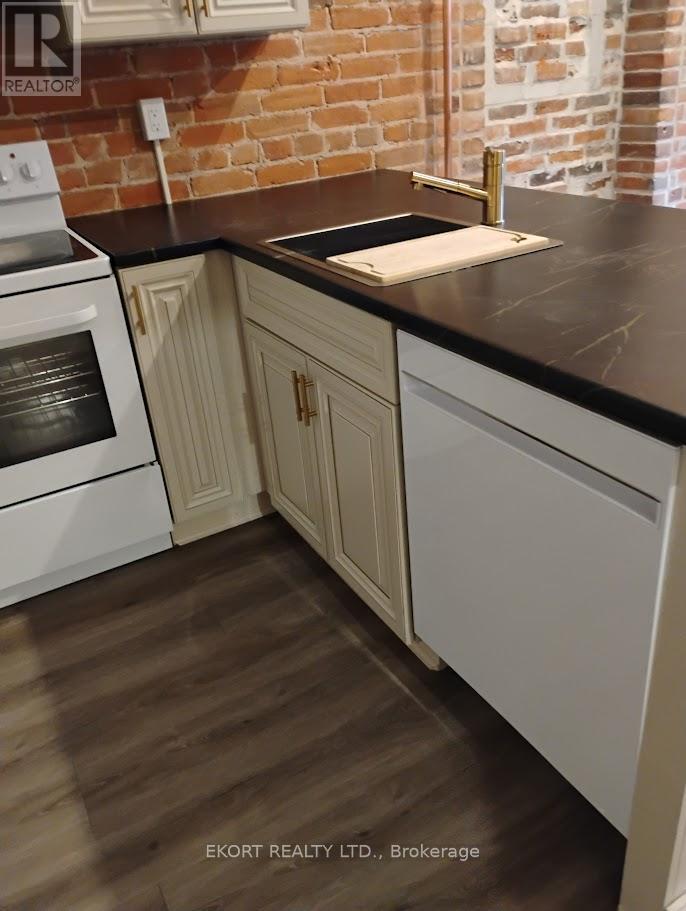 A kitchen with white cabinets and a black countertop.