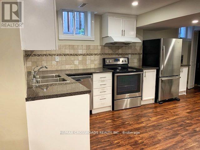 A kitchen with white cabinets and a black stove top oven.
