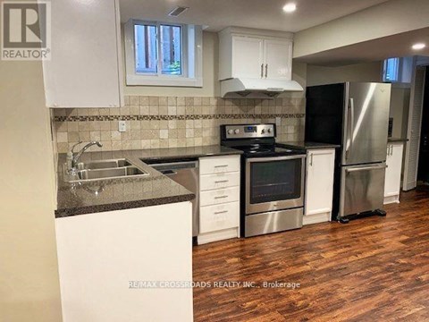 A kitchen with white cabinets and a black stove top oven.