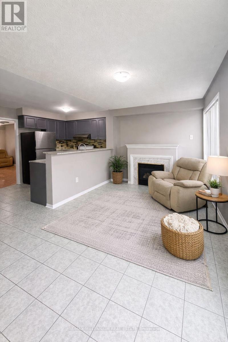 A well-lit living room with a fireplace and a grey sofa.