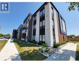 A modern apartment building with a clear blue sky above.