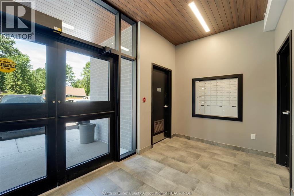 A hallway with a wooden ceiling, a glass door, and a calendar on the wall.