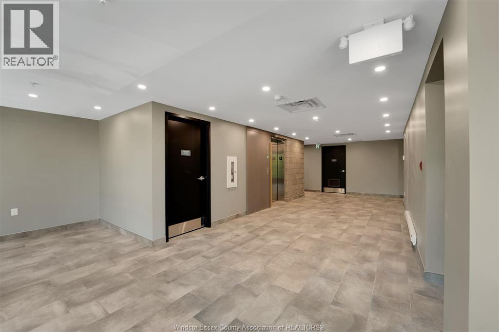 A spacious room with a tiled floor and a ceiling with recessed lighting.