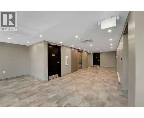 A spacious room with a tiled floor and a ceiling with recessed lighting.