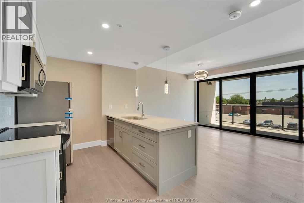 A kitchen with a sink and a window overlooking a parking lot.