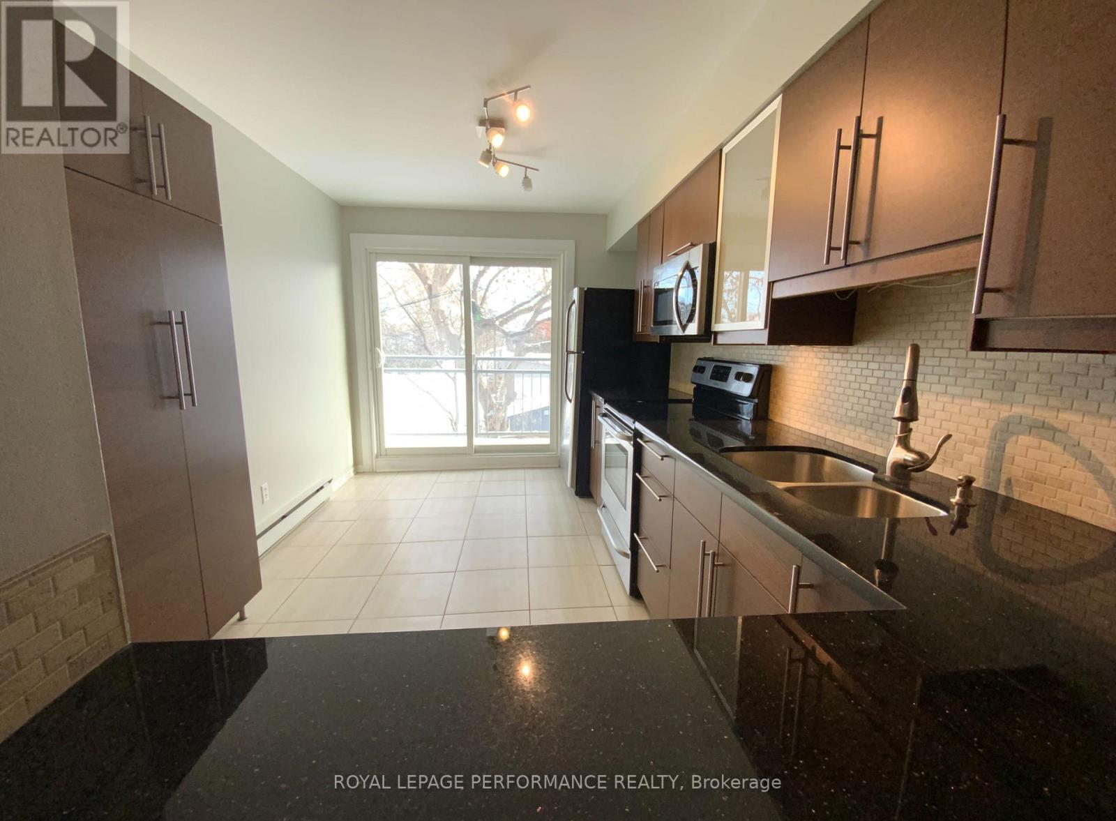 A kitchen with brown cabinets and a black stove top.