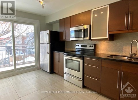 A kitchen with brown cabinets and a black stove top.