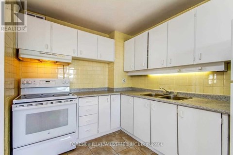 A kitchen with white cabinets and a stove top oven.
