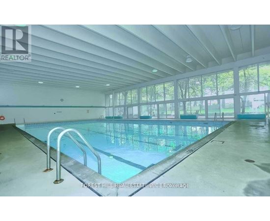 A large indoor swimming pool with a glass bottom and metal railings.