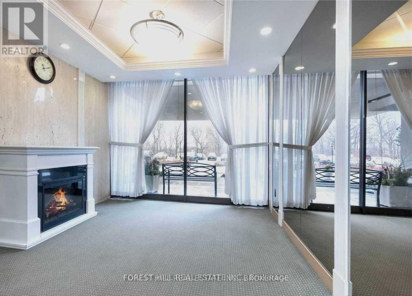 A living room with a fireplace and a clock on the wall.