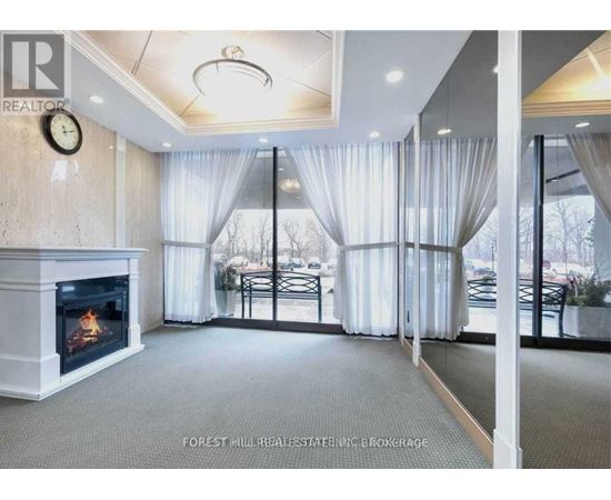 A living room with a fireplace and a clock on the wall.