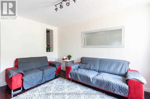 A living room with two couches and a rug.