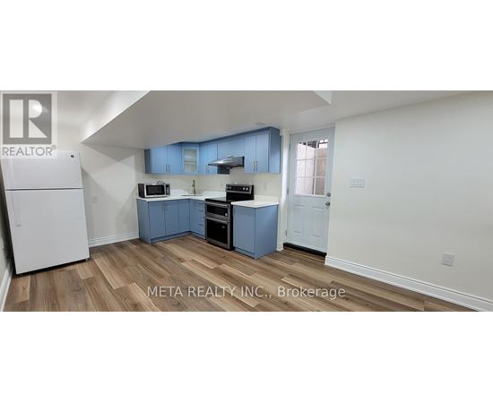 A kitchen with blue cabinets and a white refrigerator.