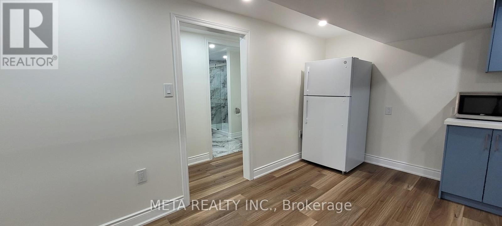 A white refrigerator in a kitchen with a blue cabinet.