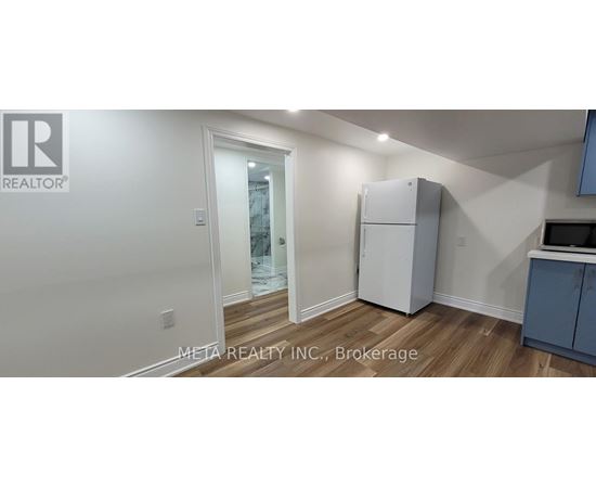 A white refrigerator in a kitchen with a blue cabinet.