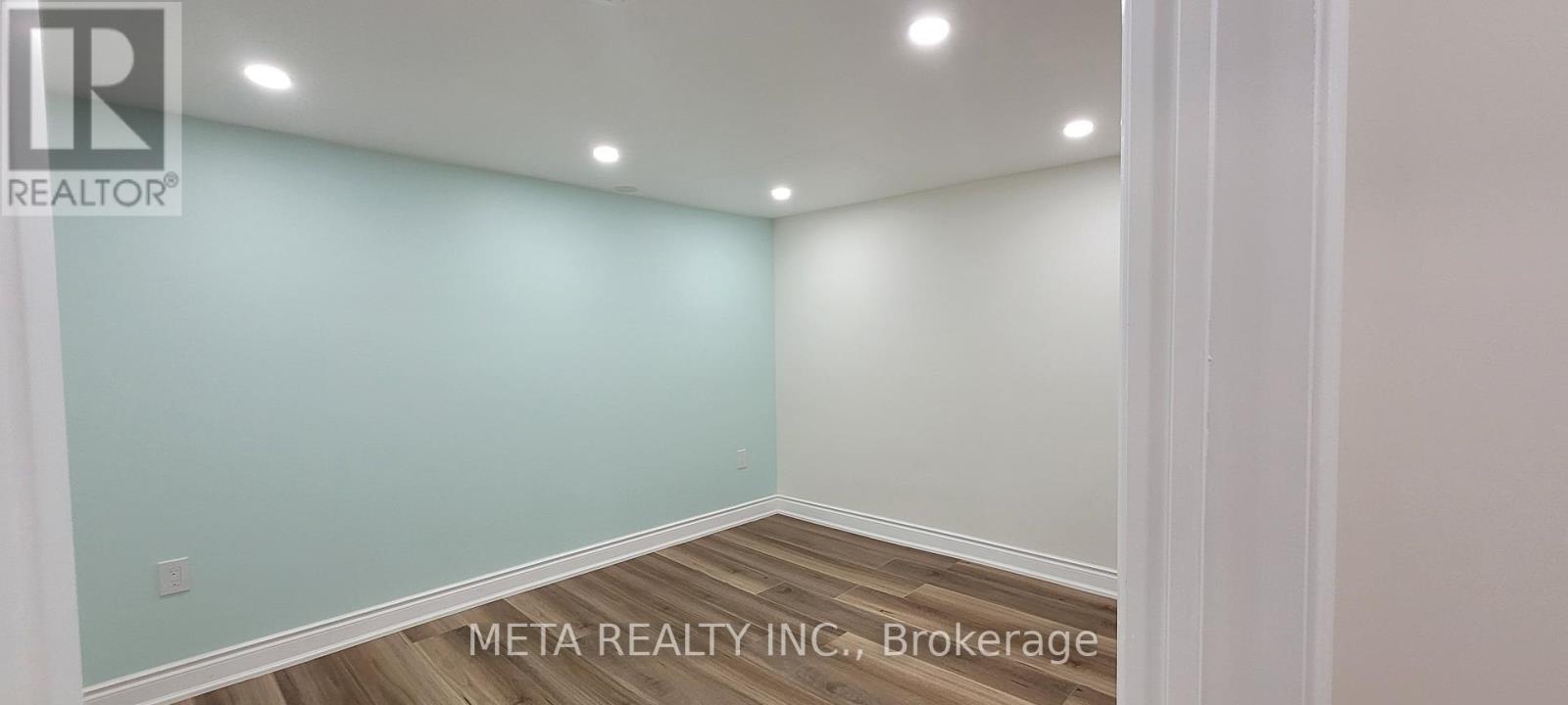 A room with a light blue wall and wooden flooring.