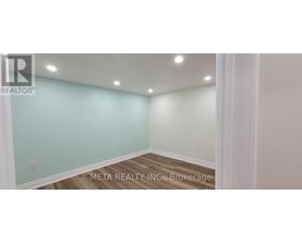 A room with a light blue wall and wooden flooring.