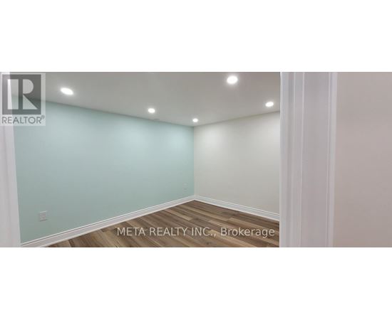 A room with a light blue wall and wooden flooring.