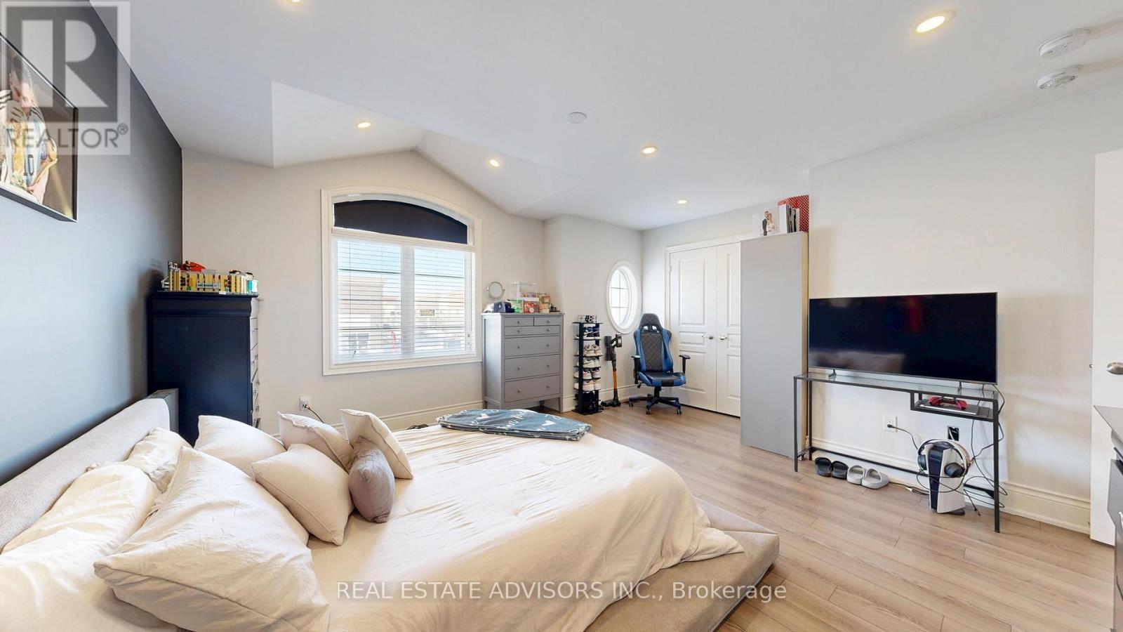A bedroom with a large bed and a flat screen TV.