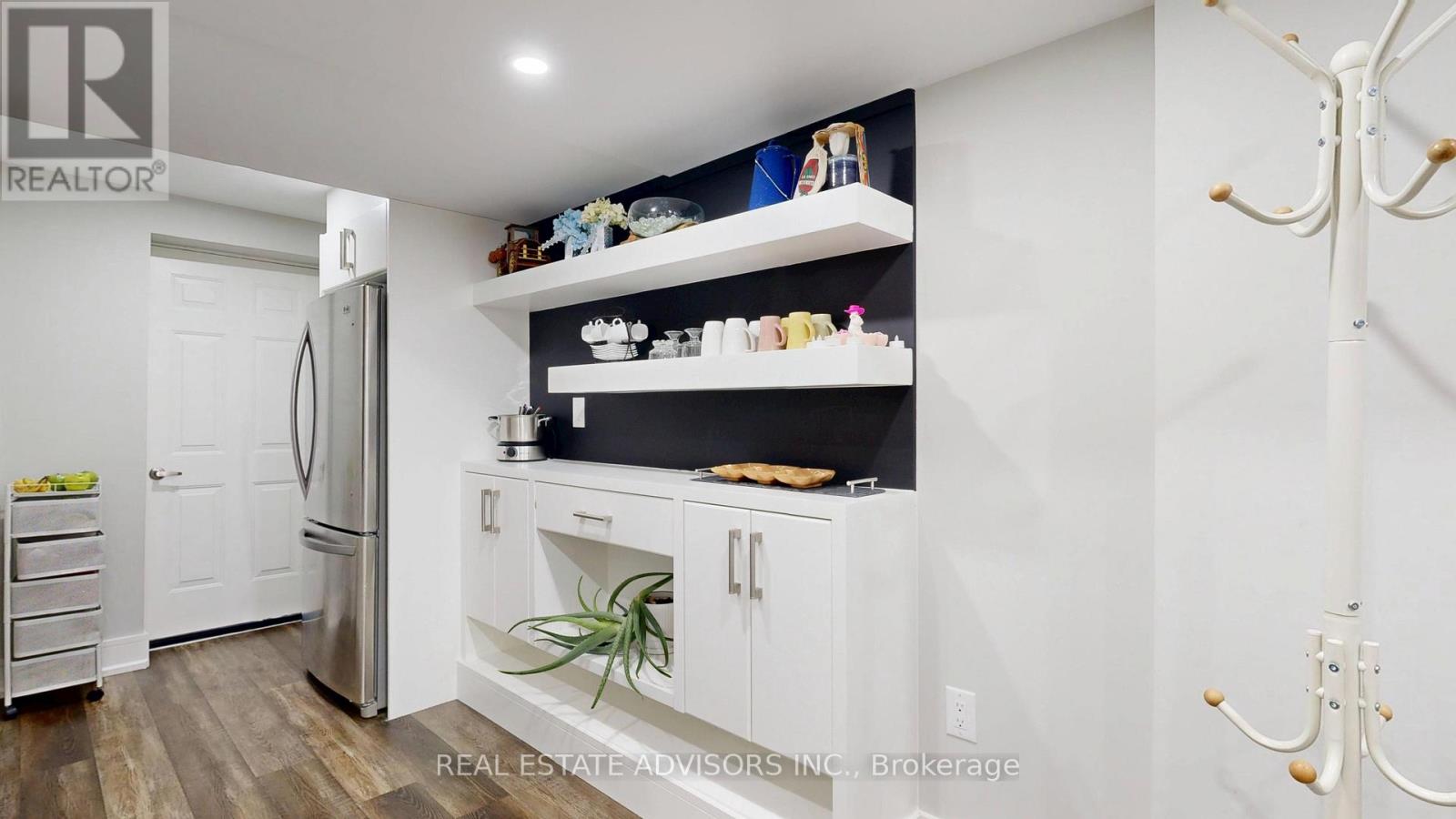 A kitchen with white cabinets and a refrigerator.