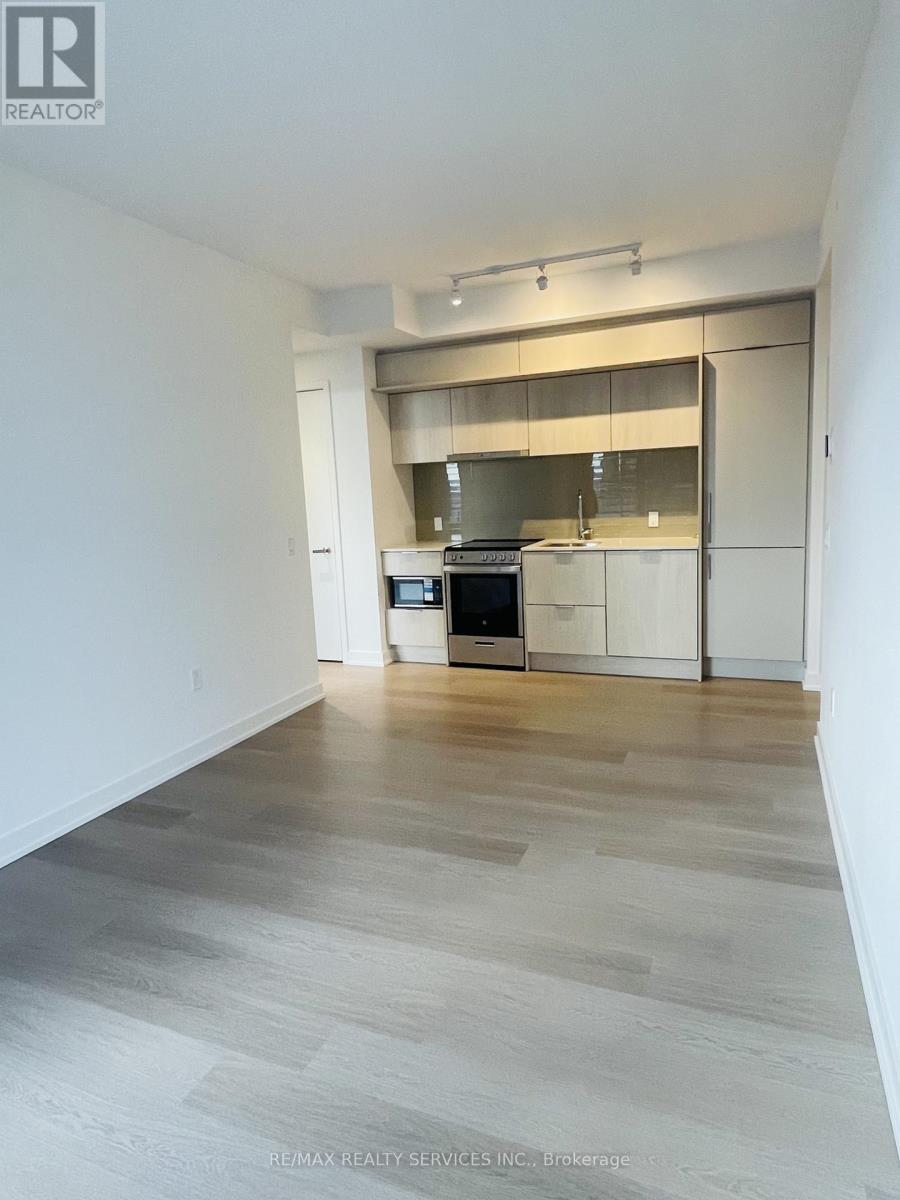 A spacious kitchen with a stainless steel oven and white cabinets.