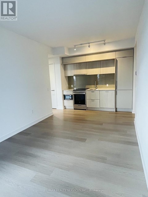 A spacious kitchen with a stainless steel oven and white cabinets.