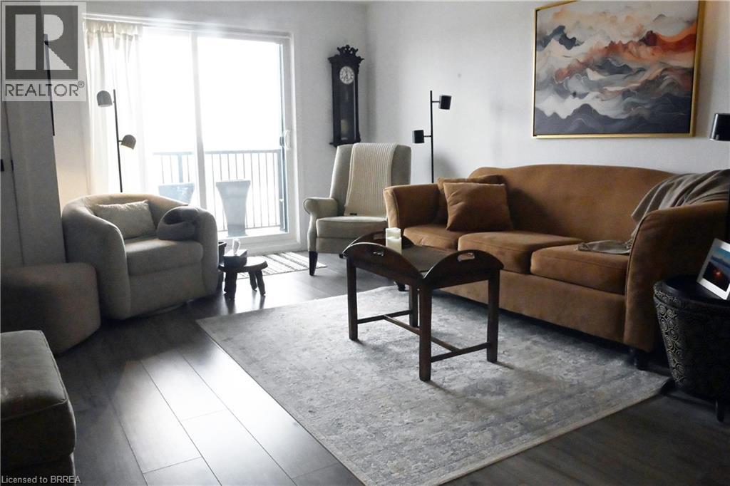A living room with a brown couch and a painting on the wall.