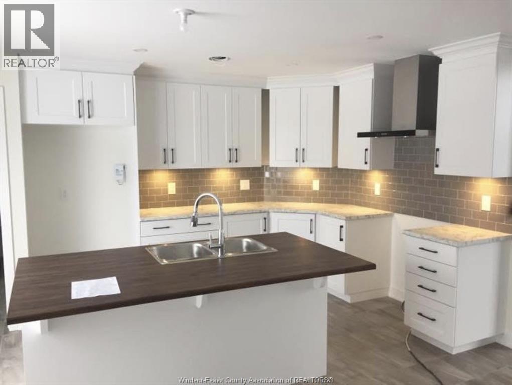 A kitchen with white cabinets and a brown countertop.