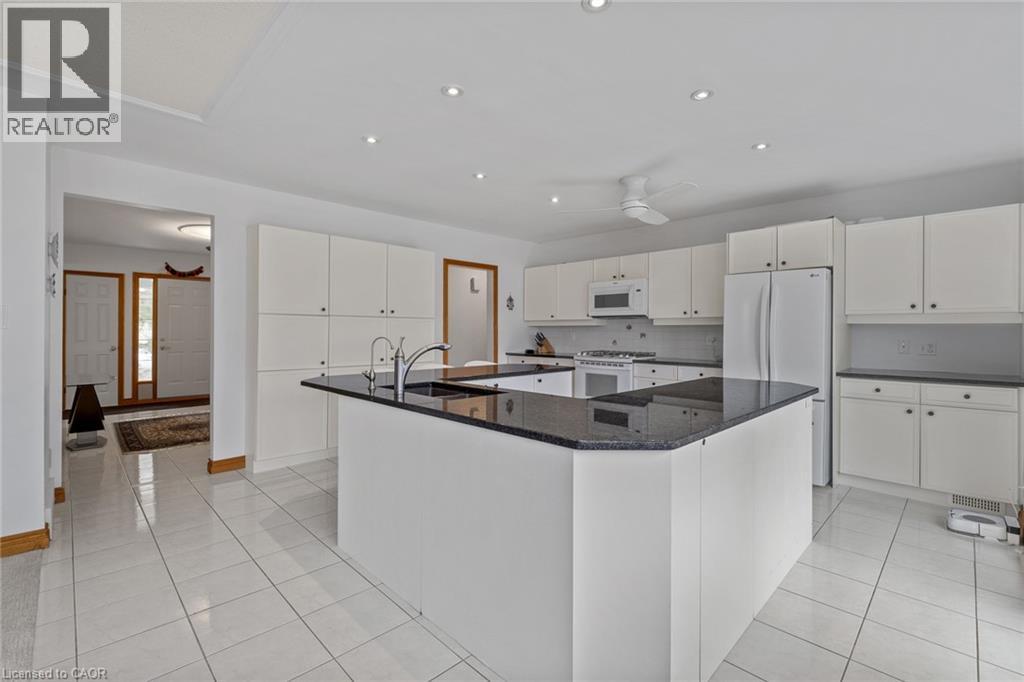 A modern kitchen with white cabinets and a black countertop.