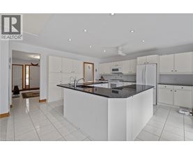 A modern kitchen with white cabinets and a black countertop.