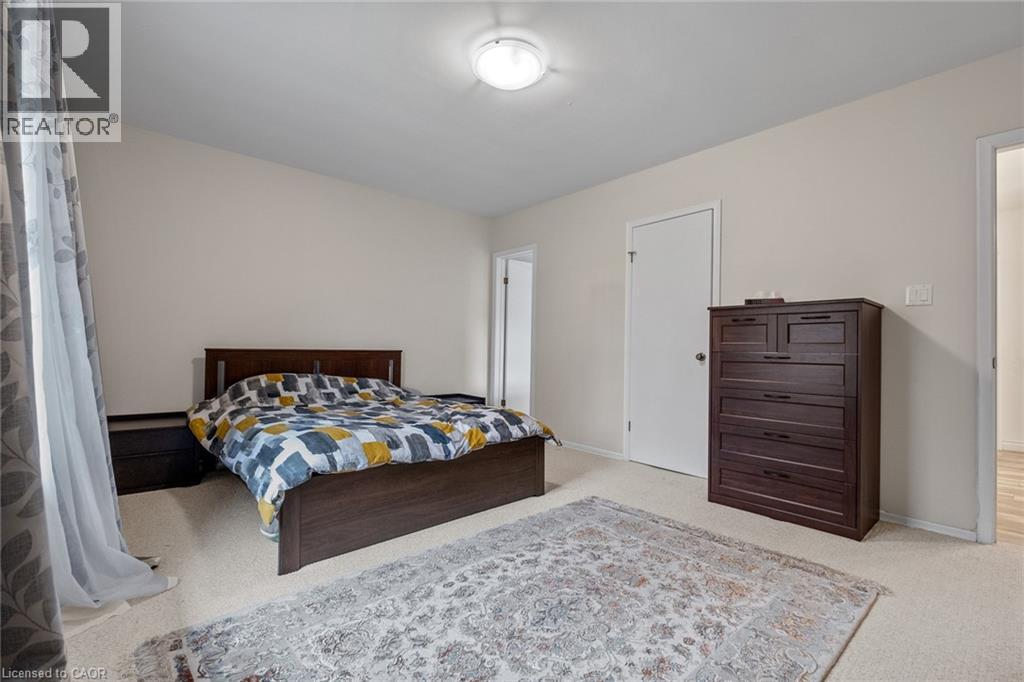 A bedroom with a bed, dresser, and rug.