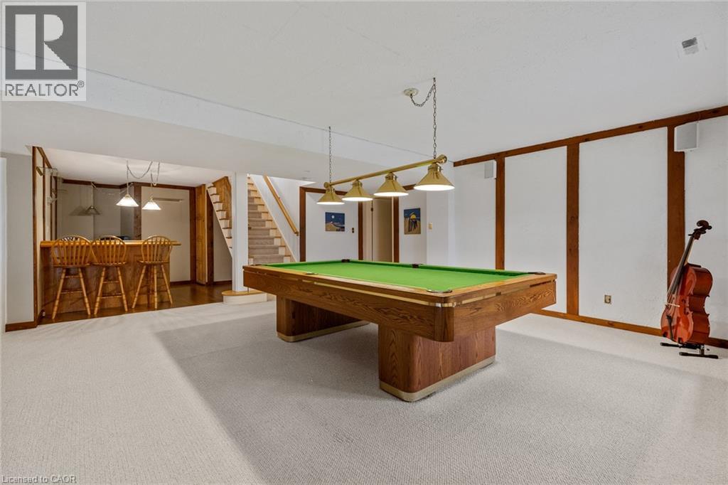 A pool table in a room with a guitar and a chair.