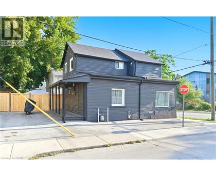 A grey house with a stop sign in front of it.