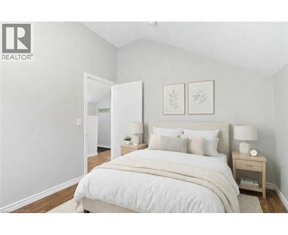 A bedroom with a large bed and two nightstands.