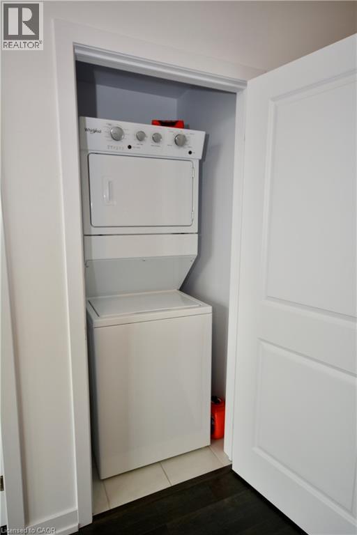 A white dishwasher and dryer are stacked in a small space.