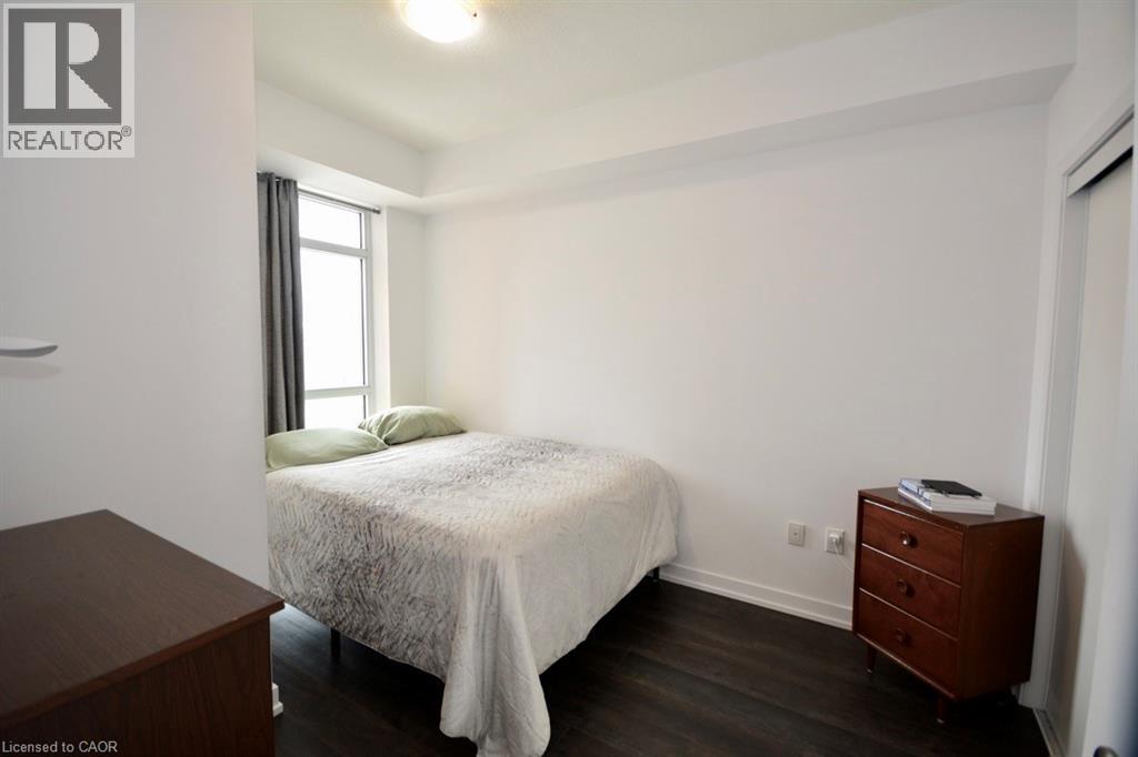 A bedroom with a bed, nightstand, and window.
