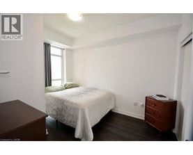 A bedroom with a bed, nightstand, and window.