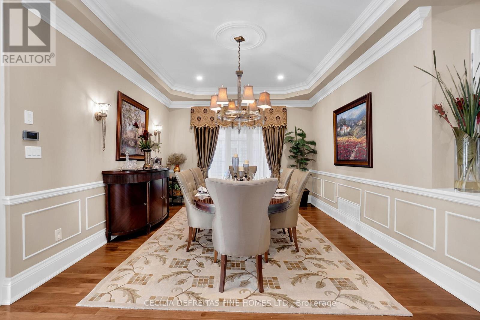A well-lit dining room with a large table and chairs.