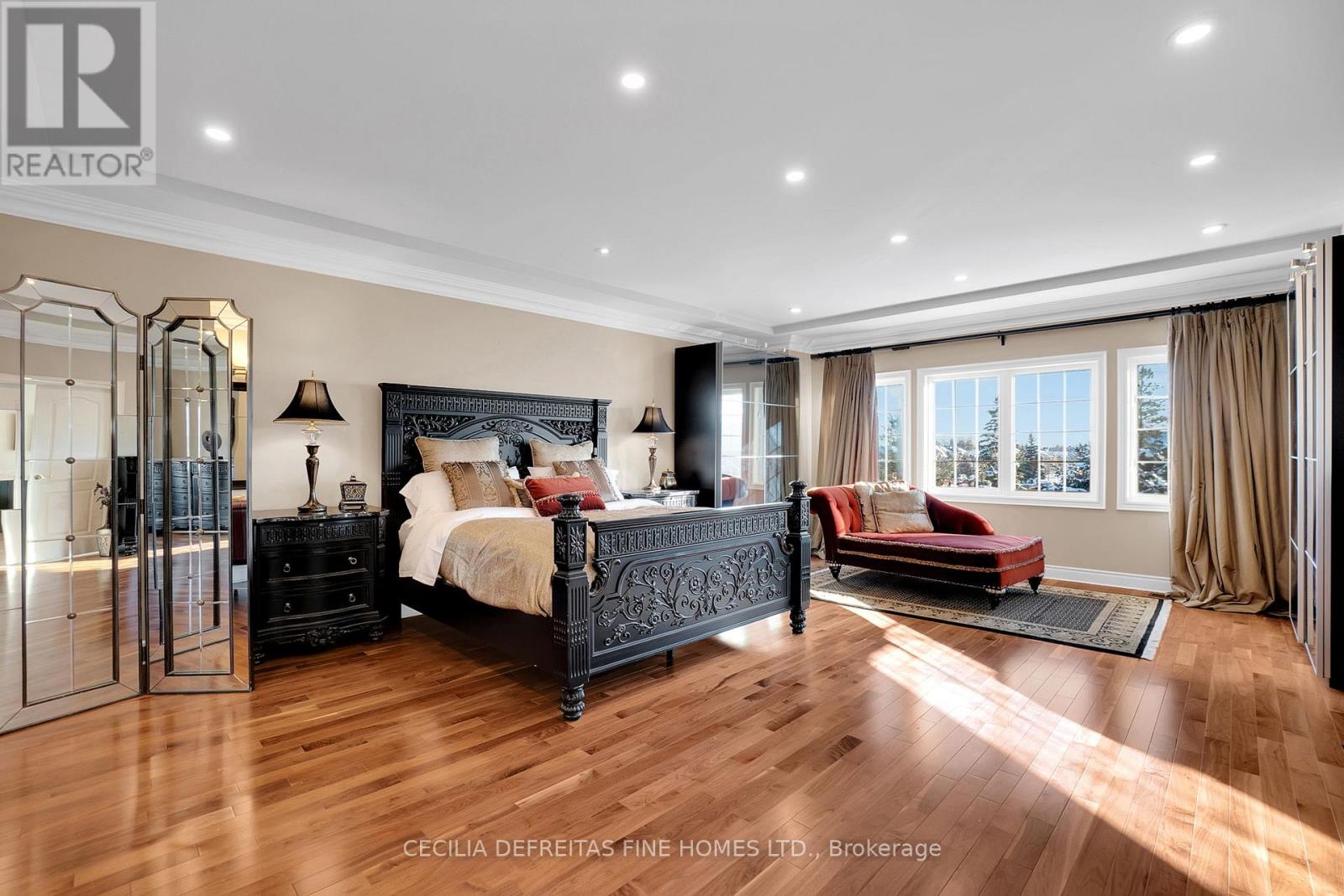 A bedroom with a large bed and a wooden floor.