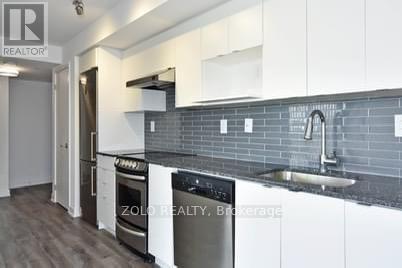 A modern kitchen with a stainless steel oven and a white countertop.