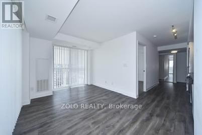 A spacious room with wooden flooring and white walls, labeled as Brokerage by Zolo Realty.