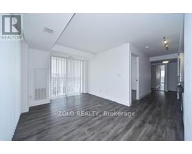 A spacious room with wooden flooring and white walls, labeled as Brokerage by Zolo Realty.