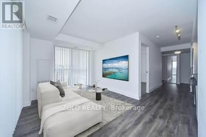 A modern bedroom with a large bed and a painting on the wall.