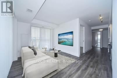 A modern bedroom with a large bed and a painting on the wall.