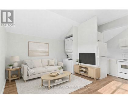A living room with a white couch, a wooden coffee table, and a television on a wooden stand.