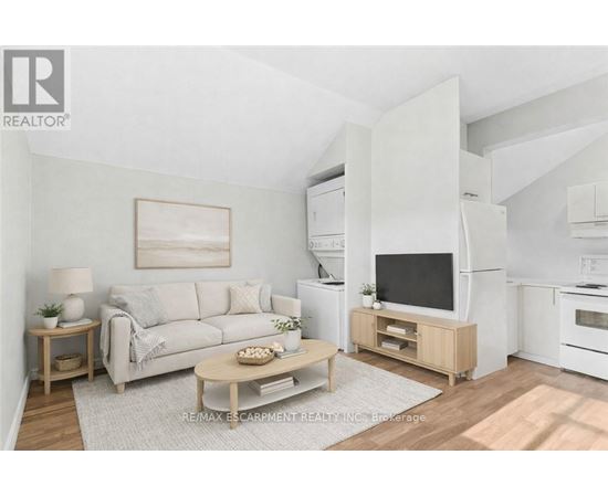 A living room with a white couch, a wooden coffee table, and a television on a wooden stand.