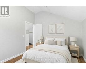 A bedroom with a large bed and two nightstands.