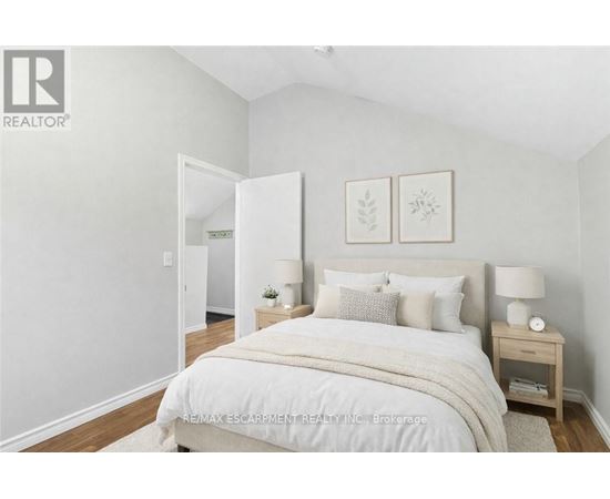 A bedroom with a large bed and two nightstands.
