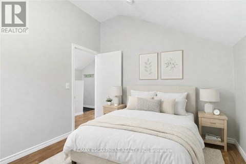 A bedroom with a large bed and two nightstands.