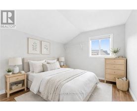 A bedroom with a bed, nightstands, and a window.